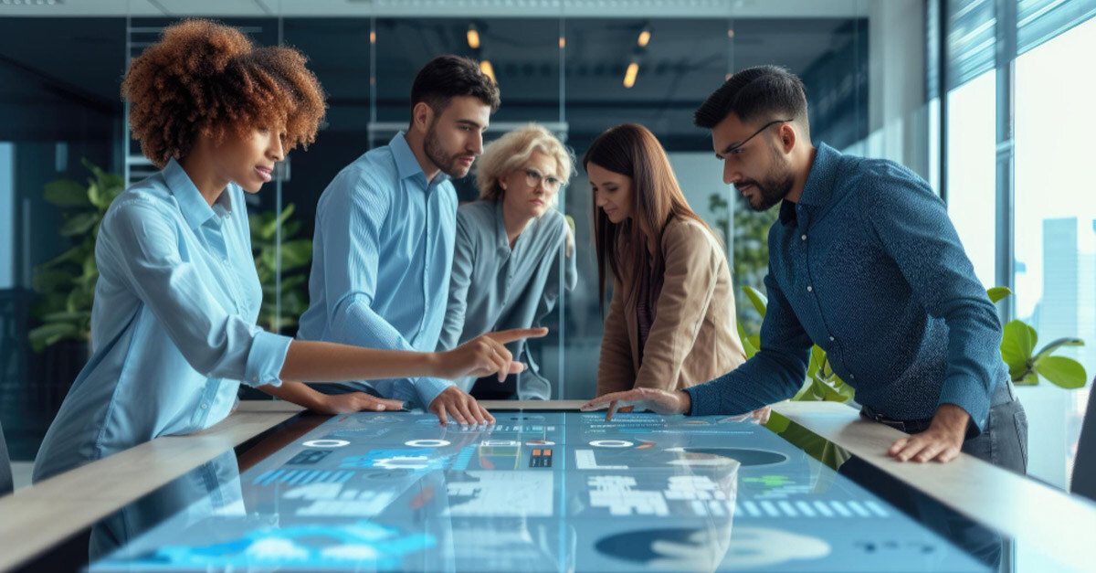 team of professionals working around a large, horizontal monitor filled with data charts - iTalent Digital blog